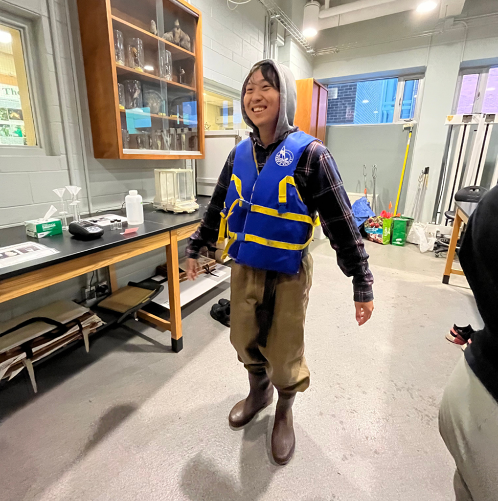 Jaydon suited up in waders and a life vest for a field research day with the Faculty of Environment
