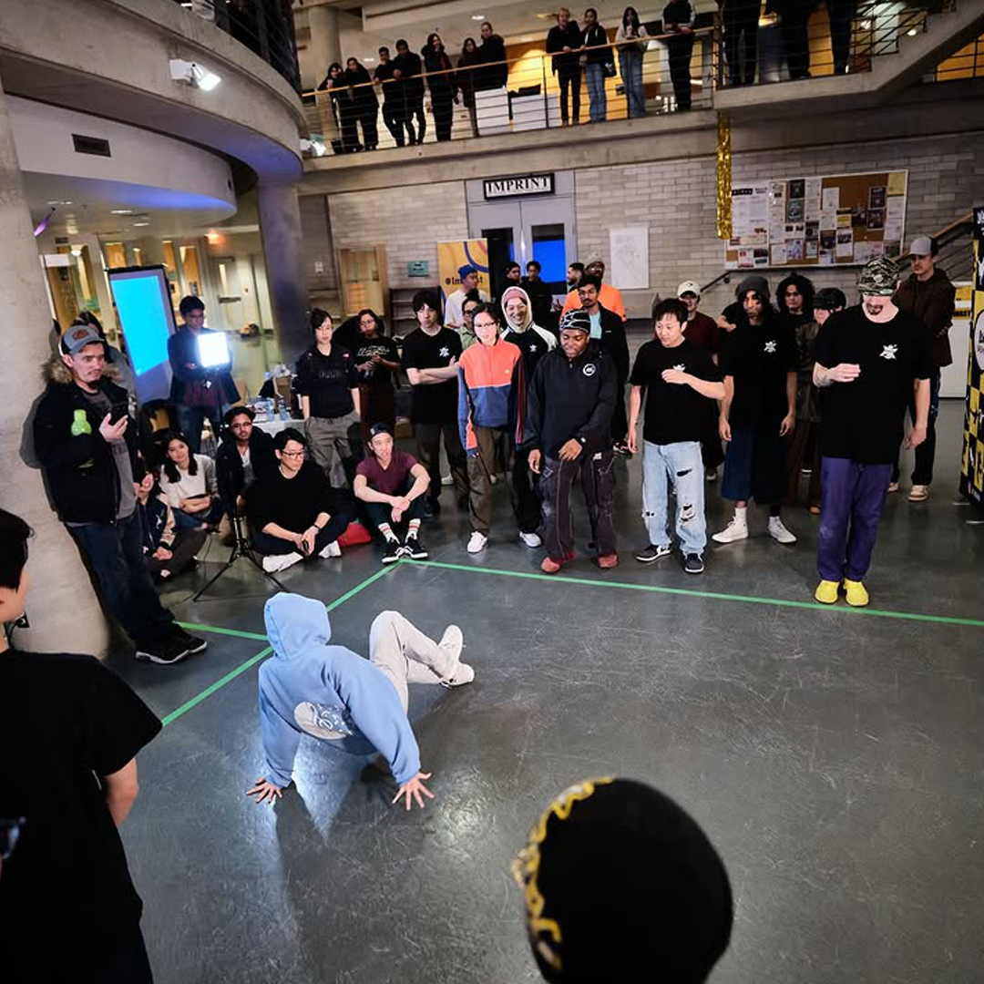 A breaker performing inside a circle of dancers and judges at Ground FX